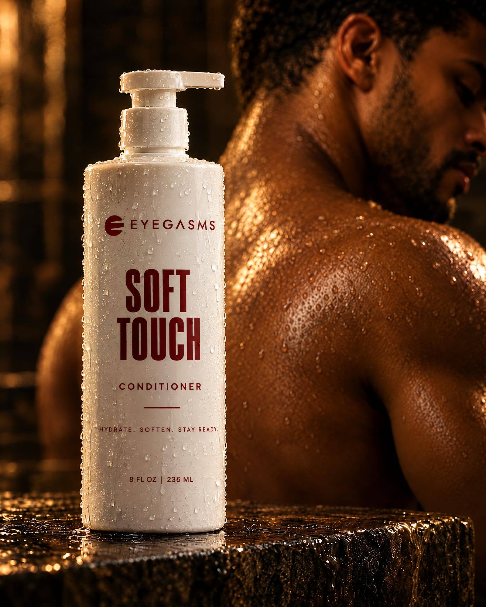 Soft Touch, conditioner, by EYEGASMS: a white pump bottle with oxblood lettering, beaded with water, a man's wet shoulder glowing in warm light behind it.