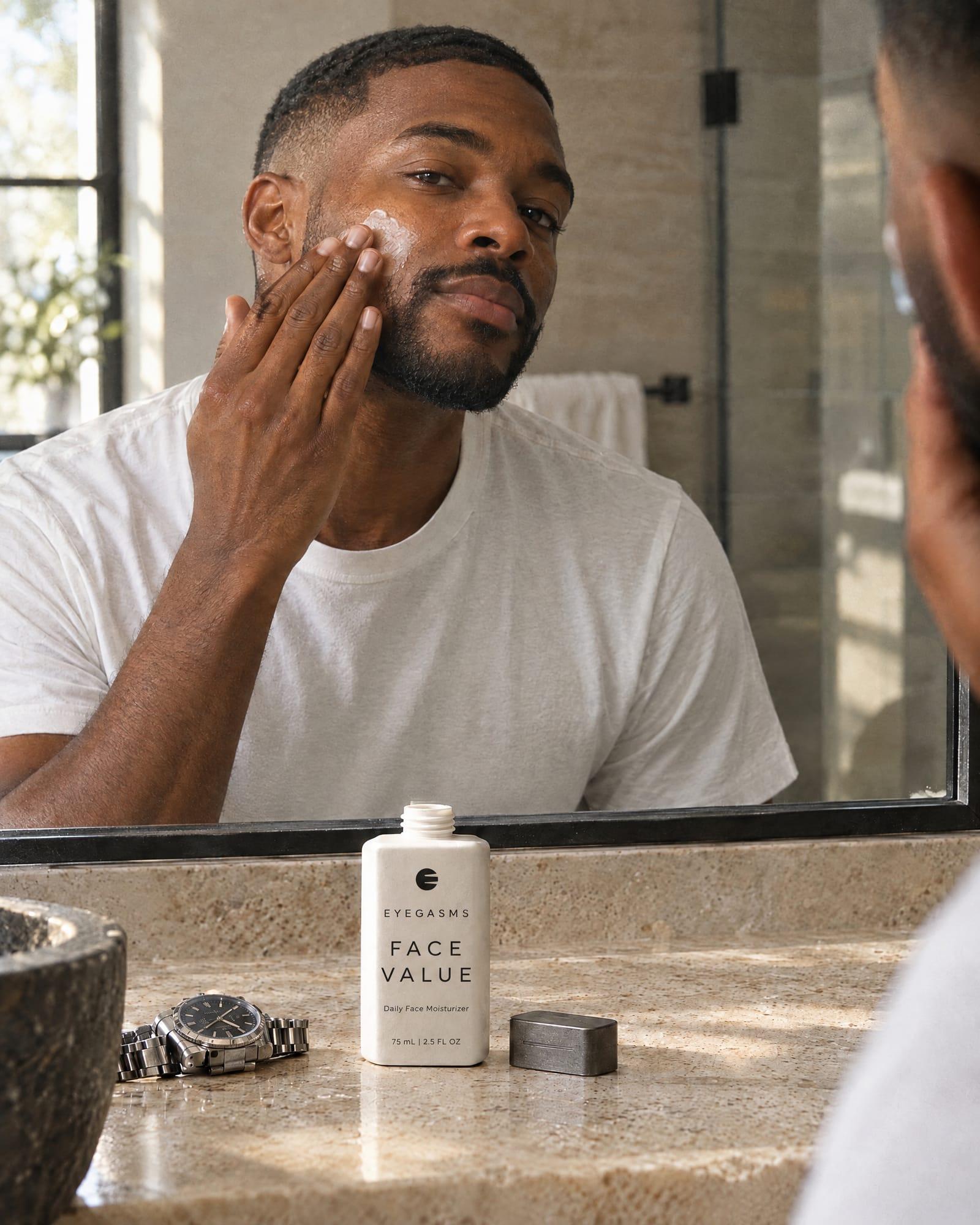 Face Value, daily face moisturizer, in EYEGASMS E-Form packaging: a Black man presses moisturizer into his cheek at a bathroom mirror; the bone bottle stands on the counter.